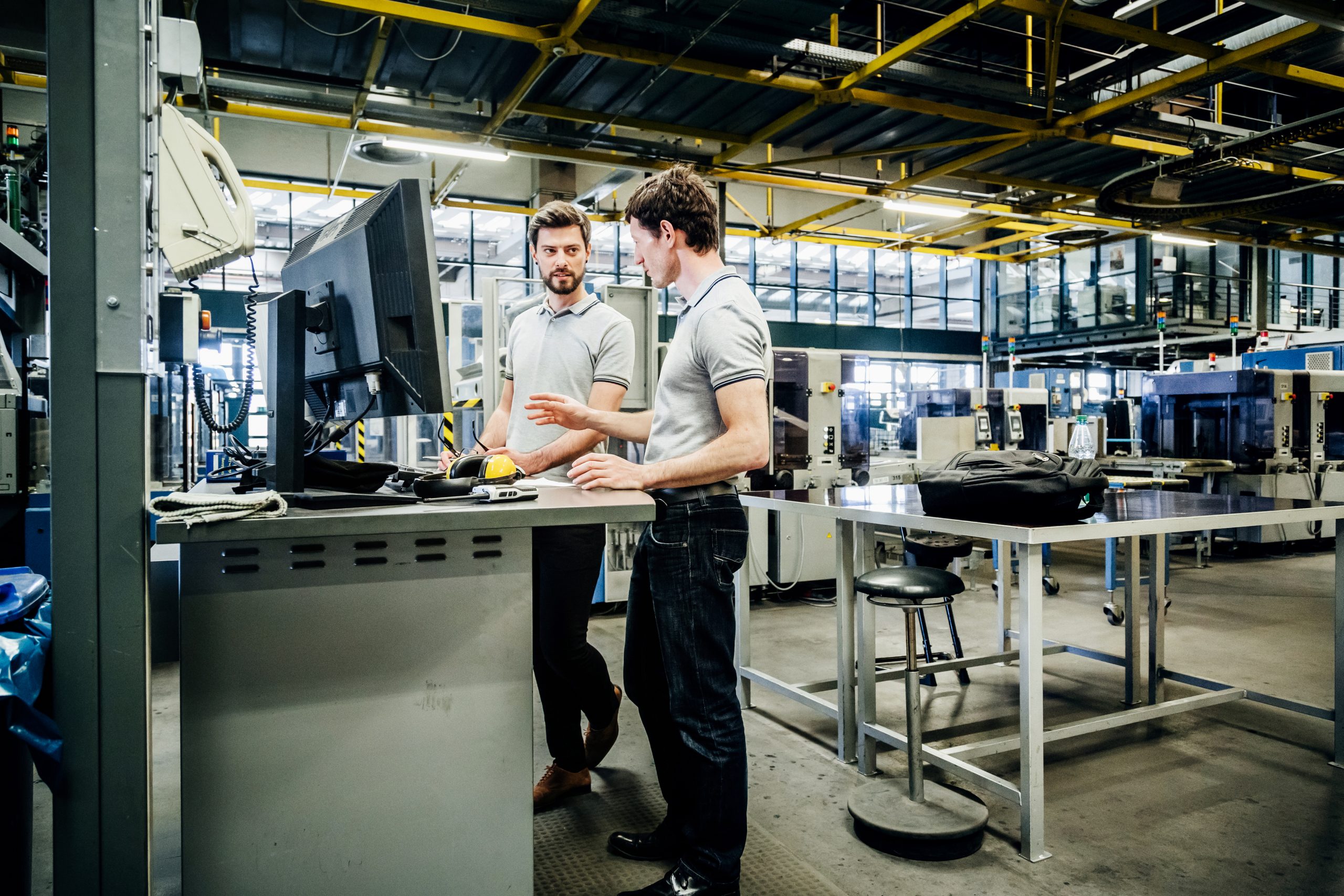 Deux collaborateurs travaillent debout devant leurs ordinateurs