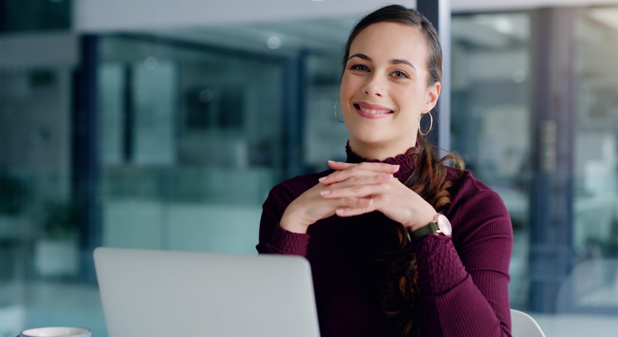 Une collaboratrice OGI souriante travaille devant son ordinateur